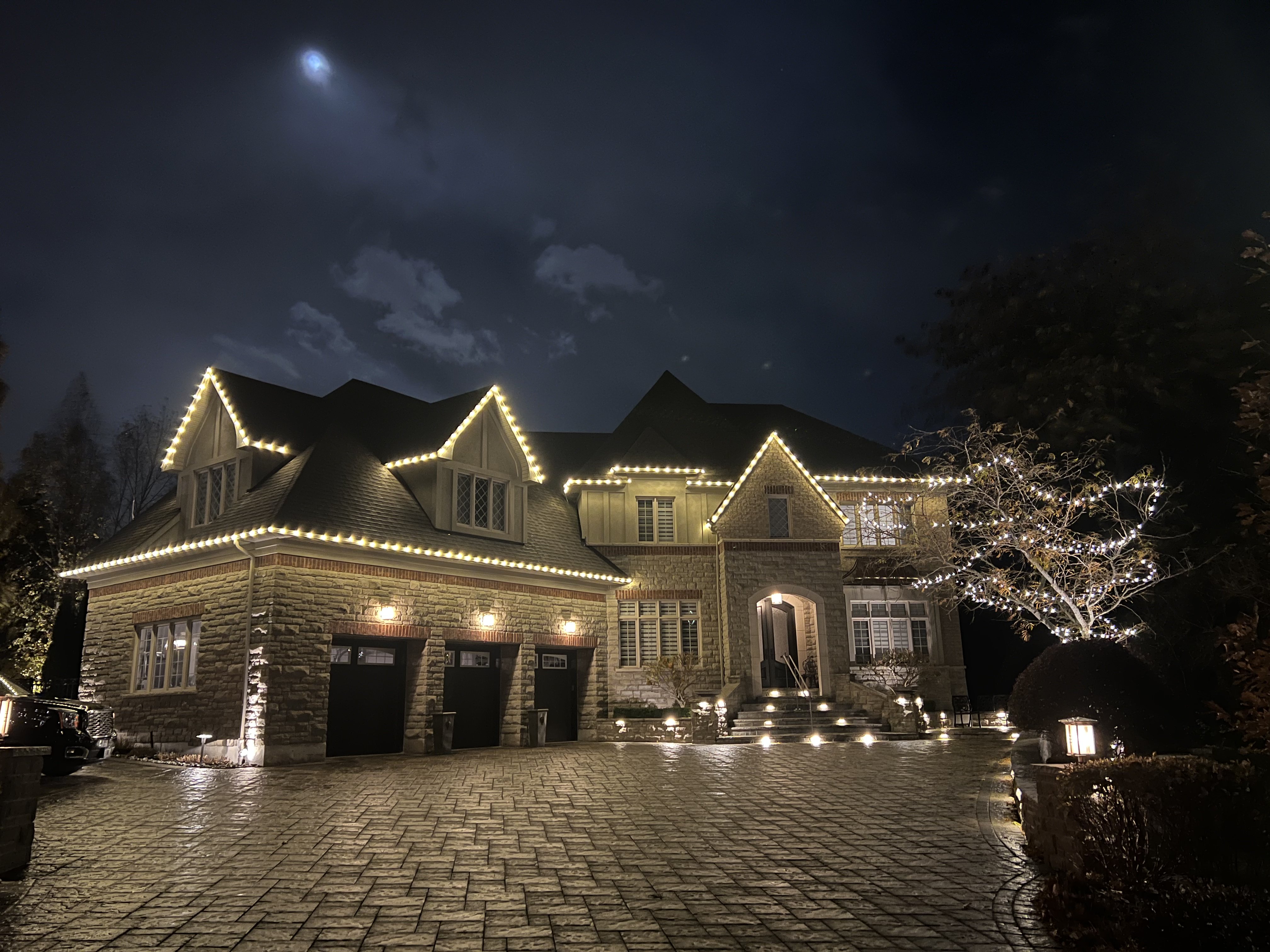 Home with professionally installed warm-white holiday lights at dusk